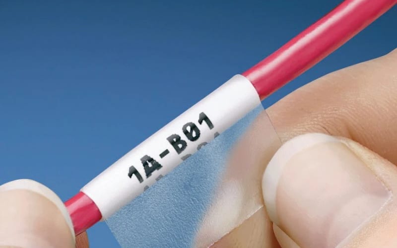 Self-laminating wrap label reading 1A-B01 around a wire