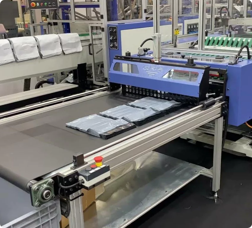 Poly mailer converter machine with finished mailers on the conveyor at the Synergy Tijuana plant
