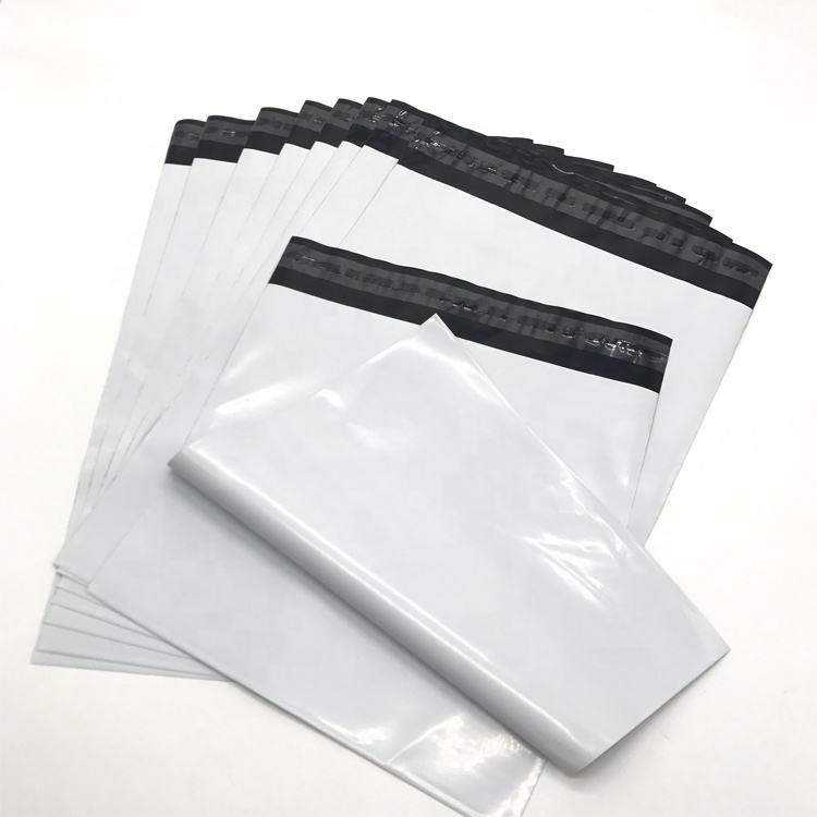 A stack of finished white poly mailers, cased and ready to ship — the inventory position a brand wants to be in before November