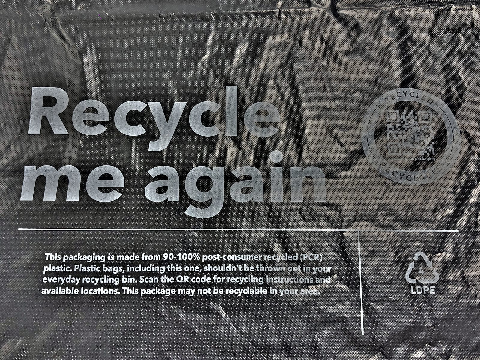 Close-up of white flexographic print on the textured film — headline type and body copy holding clean edges across the embossed surface