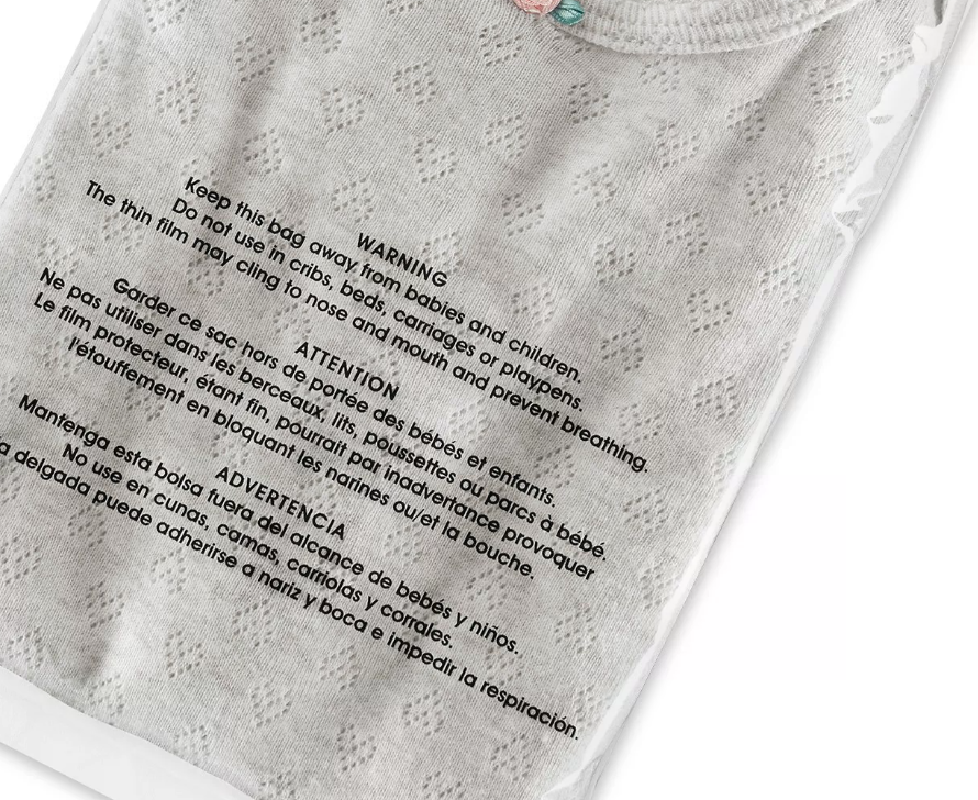 Suffocation-warning poly bag with a gray t-shirt inside, warning text visible on the bag face
